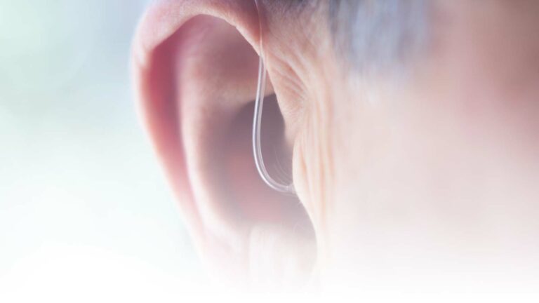 Featured Image - Can hearing aids help with tinnitus management? - Closeup of ear and hearing aid